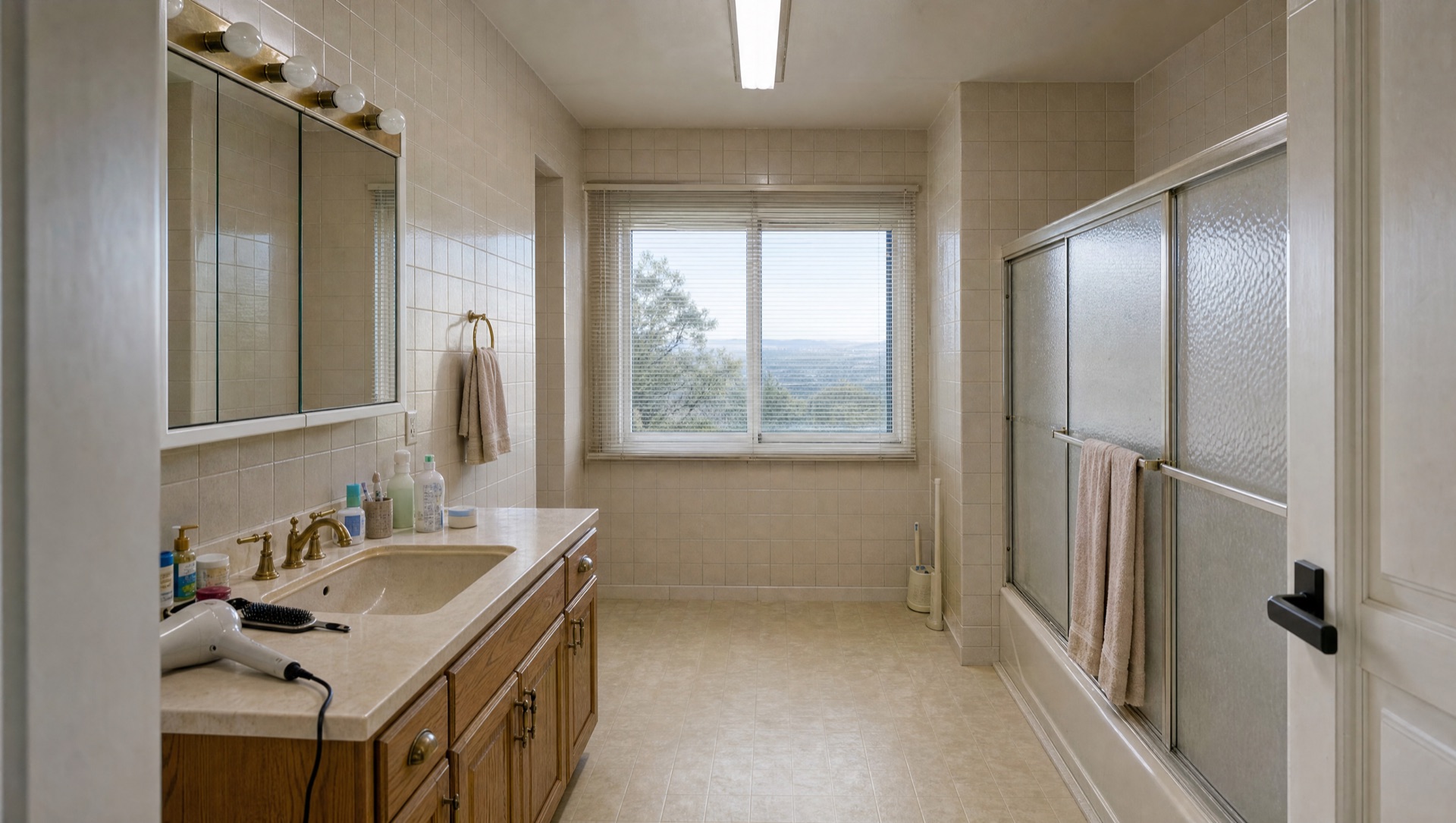 Dated 1980s Del Cerro primary bathroom with beige ceramic tile and tub-shower combo